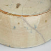 Close-up of a ceramic plate with a crack and speckled pattern on a white background