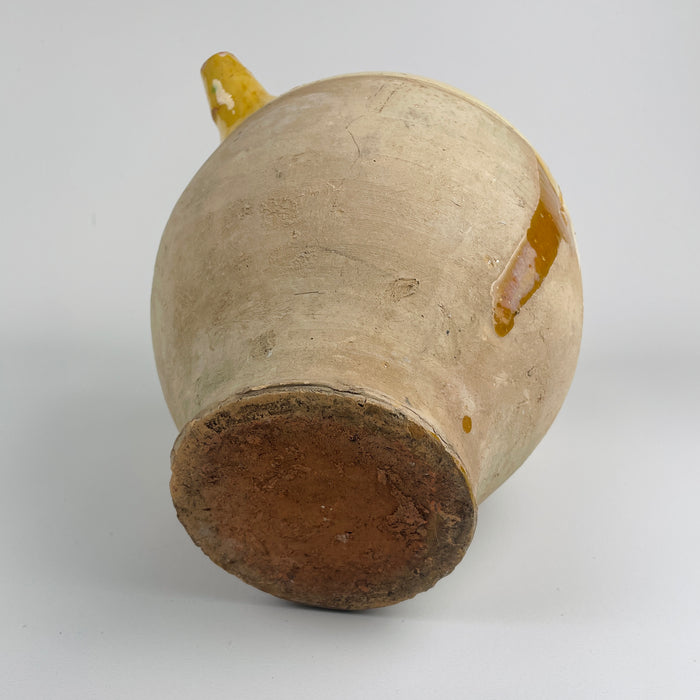 The base of the antique French gargolette is shown clearly, highlighting the unglazed terracotta clay, firing marks, and aged patina developed over decades. These features confirm its hand-thrown 19th century origin. The pot’s rustic authenticity complements farmhouse decor, cottage decor, rustic home decor, french country decor, and mediterranean decor, making it ideal for shelves, consoles, or kitchen displays that value natural materials.