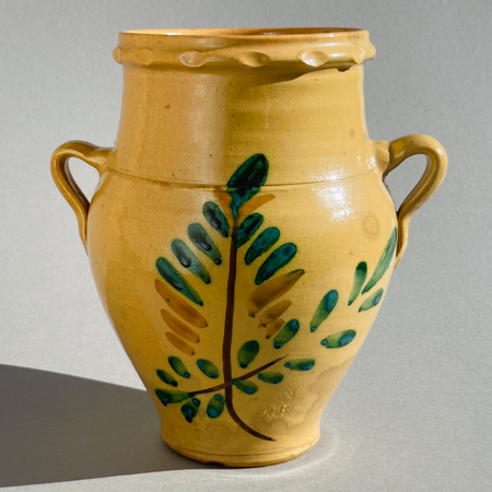 Front view of antique Andalusian "orza" from Lucena, Córdoba, featuring straw-yellow glaze and hand-painted "Tree of Life" olive branch motif, early 20th century.