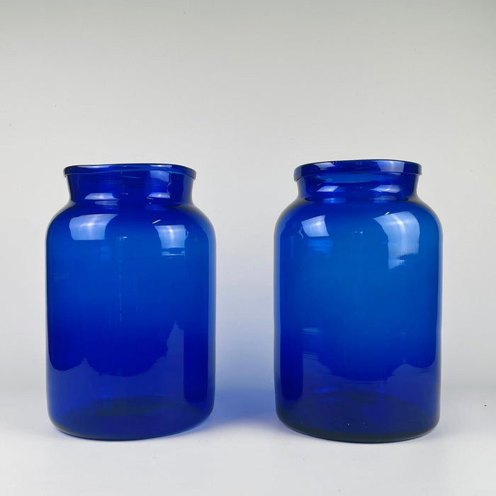 body of one vase, showing density variations in the cobalt pigment and natural air inclusions inside the glass. These qualities demonstrate pre-industrial glassmaking techniques. The deep blue colour makes the vase a strong candidate for French country decor, rustic farmhouse displays, and Mediterranean style arrangements.