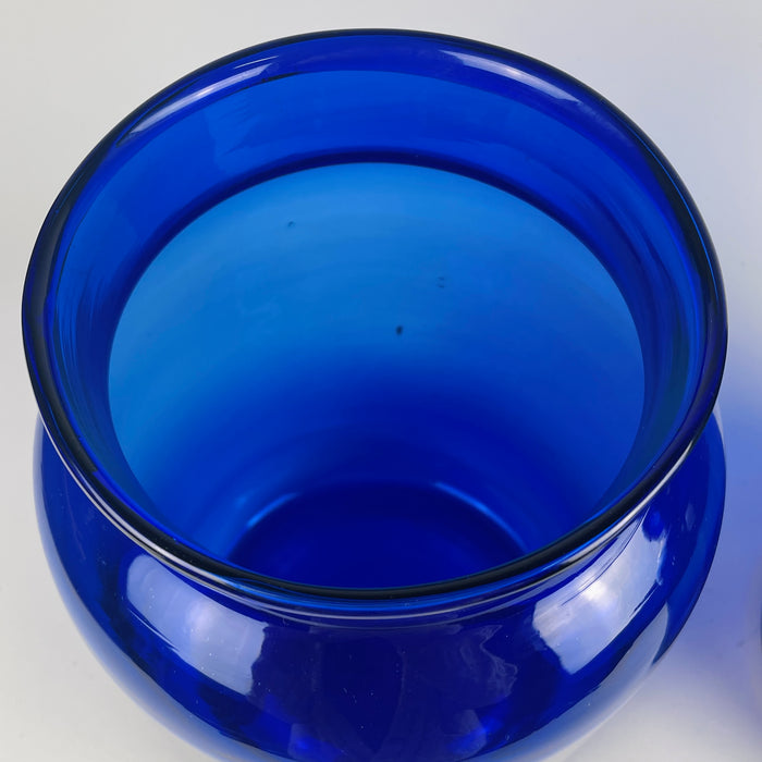 Close-up capturing cobalt light refraction through the thick glass walls of one vase. The intensity of the colour results from cobalt oxide pigments historically used in both apothecary jars and decorative pieces. This image highlights potential for Global Eclectic Decor, vintage European displays, and bold sculptural glass arrangements.