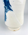 A large Talavera style Spanish ceramic pharmacy jar displaying the transition from its broad rounded lip to its short neck and full shoulders. The cobalt blue eagle design wraps partially around the curved body, with featherwork and shield decoration emerging against the creamy white glaze. Subtle speckling and small glaze irregularities remain visible across the handmade pottery surface.
