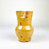Spanish folk pottery jug in warm yellow glazed earthenware, sourced in Peñafiel in the province of Valladolid. The handmade pitcher combines a pinched spout, gently irregular rim and loop handle with a compact 15.5 cm form, making it a strong antique ceramic accent for rustic home decor and collected Mediterranean pottery.