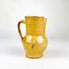 Antique Spanish yellow terracotta jug dating to the late 19th century, wheel thrown in red earthenware and finished with a warm honey glaze. The compact pitcher has a rounded belly, tall cylindrical neck, pinched pouring spout, circular foot and applied loop handle, with aged wear suited to Mediterranean decor and Spanish folk pottery collections.