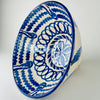 Large Los Arrayanes lebrillo bowl formed from terracotta earthenware and finished with a creamy glaze, cobalt rim and sweeping blue exterior brushstrokes. The handmade profile is slightly irregular, with a wide mouth and sturdy footed base that emphasize the scale and weight of this Granada serving bowl and decorative Spanish ceramic.