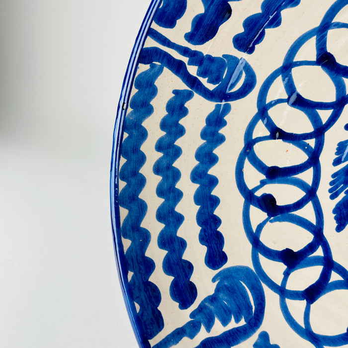 Blue and white Spanish Fajalauza bowl by Cerámica Los Arrayanes, with an open flared profile and a richly decorated interior of floral, looping and scalloped motifs. The cobalt brushwork continues across the outer wall in broad gestural marks, creating a large handmade Granada pottery centerpiece suited to serving, tabletop display or wall decor.