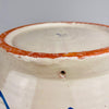 Pierced hanging hole within the foot ring of the large Los Arrayanes Fajalauza bowl, allowing the ceramic to be displayed as Spanish wall art. The surrounding base shows exposed reddish terracotta, glaze rubbing and handmade surface texture, all consistent with the construction and previous display of this heavy Granada pottery lebrillo.