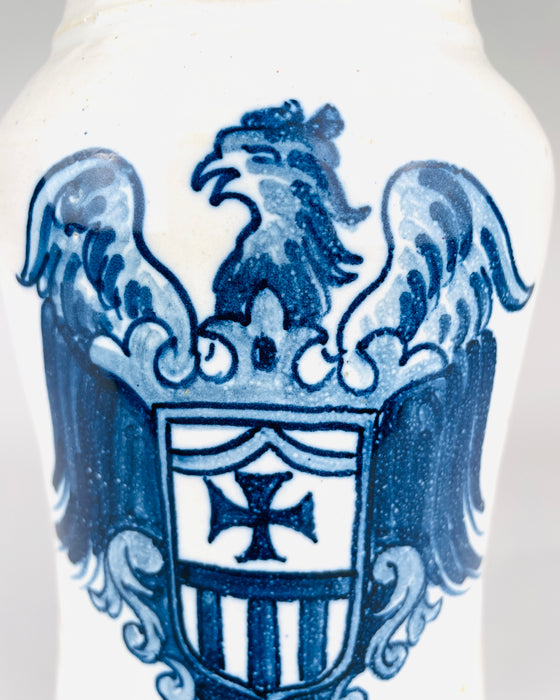 A Spanish Talavera albarello reveals the rounded white glazed rim and visible concentric throwing lines descending through the interior. The inner surface shifts toward a warmer buff tone deeper inside the vessel. This wheel thrown earthenware pharmacy jar has a thick flared mouth that contributes to its distinctive historical ceramic form.