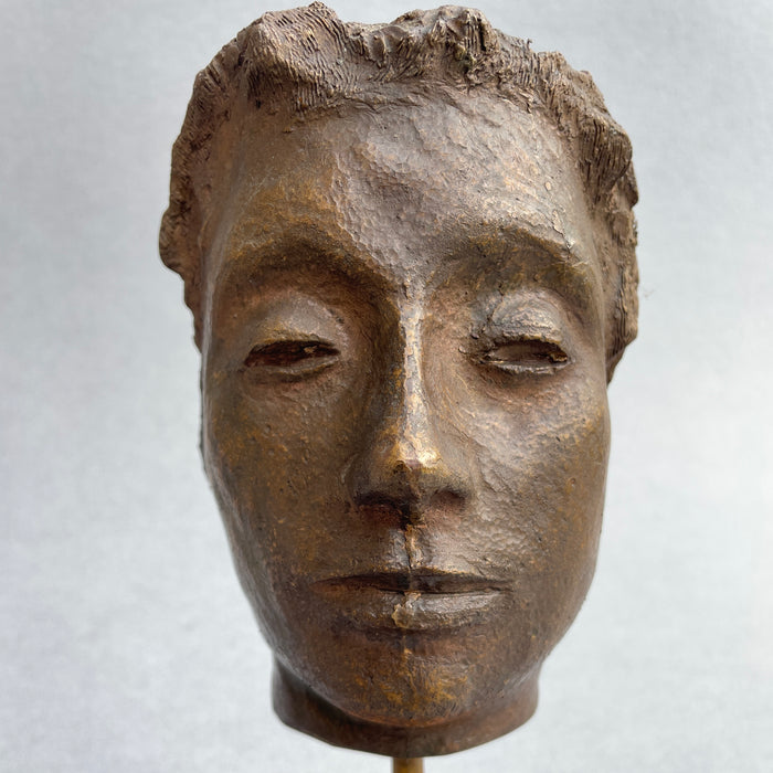 Full frontal view of a mid-century bronze head bust with soft expression and a warm patinated finish, designed by Postwar artist Pistelli.