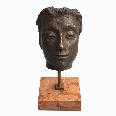 Bronze sculpture of a serene human head by Piergiorgio Pistelli mounted on a red marble plinth with brass stand, shown front-facing against a grey background.