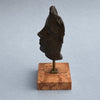 Side angle photo of Maschera by Piergiorgio Pistelli showing the sculptural volume and contours of the stylized bronze head on its elegant plinth.
