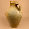Vintage ceramic jug with a handle on a beige background. Atmospheric setting featuring the antique cántaro placed on terracotta flooring, evoking Andalusian farmhouse charm. The earthy palette enhances wabi sabi and coastal Mediterranean home styling.