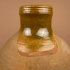 Close-up of a ceramic jar with a brownish-green glaze. Three-quarter view of the cántaro jug emphasizing symmetry and natural patina. Its hand-formed spout and handle pair perfectly with neutral-toned interiors and organic Mediterranean design.