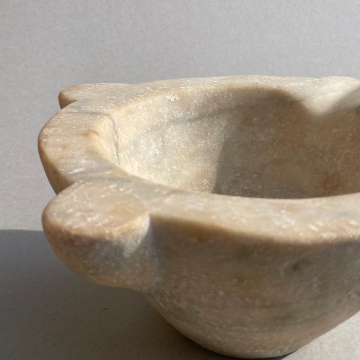 Hand-carved marble antique mortar, showcasing French craftsmanship and worn surface from 18th-century use.
