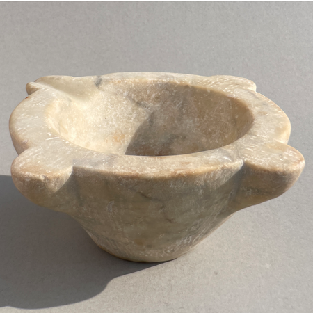Angled view of antique marble apothecary mortar from France, featuring sculptural carved form and rustic charm. Detailed view of French marble mortar with visible age wear, evoking traditional farmhouse aesthetics.