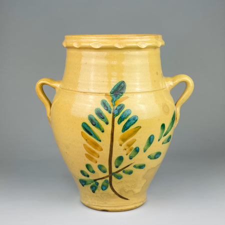 Antique Spanish orza decorative vasefrom Lucena, Córdoba, with yellow terracotta glaze and hand-painted green and brown foliate design, featuring two looped handles and a wide opening. A traditional Spanish storage vessel dating to the early 20th century.