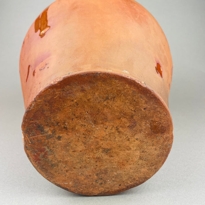 Underside and base view of the antique terracotta pot, showing the unglazed foot ring, kiln wear, and age-related abrasions from use. The heavy clay construction and stable base make it practical as a floor or hearth decorative pottery accent, suited to farmhouse decor and French country decor.