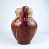 Nineteenth century Spanish terracotta vase measuring 24 cm tall, with a balanced two handled form, rounded shoulders and a flat base. The irregular amber and olive brown glaze flows across the upper red clay body while areas of exposed pottery create a graphic surface appropriate for Mediterranean decor, farmhouse decor and collected antique interiors.