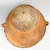 Antique Spanish pottery base showing concentric tool marks, surface abrasion and mineral discoloration across the unglazed terracotta. The broad foot is integral to the deep conical construction of the lebrillo bowl, which retains two side handles, a rolled rim and a warm glazed interior suitable for display as a rustic terracotta vase or centerpiece.