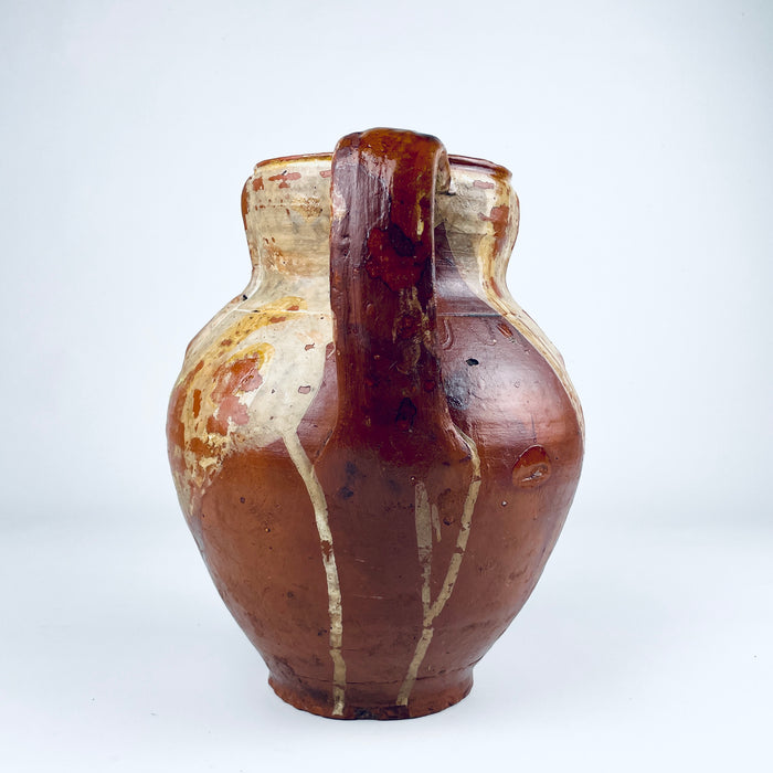 Second loop handle of the Spanish glazed terracotta vase, with visible hand shaping, darkened wear and areas where the brown glaze reveals the red clay beneath. The two handled nineteenth century pottery jar has a practical storage form and a sculptural presence suited to farmhouse decor, wabi sabi decor and antique pottery collections.
