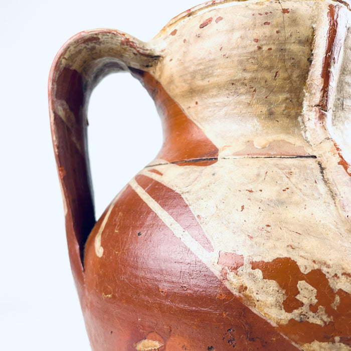 Wheel thrown Spanish terracotta vase displaying horizontal turning lines beneath the amber brown glaze and subtle hand formed irregularities throughout the body. The two handled Castilian orza jar dates to the nineteenth century and combines utilitarian pottery construction with an expressive aged surface for antique and vintage home decor.