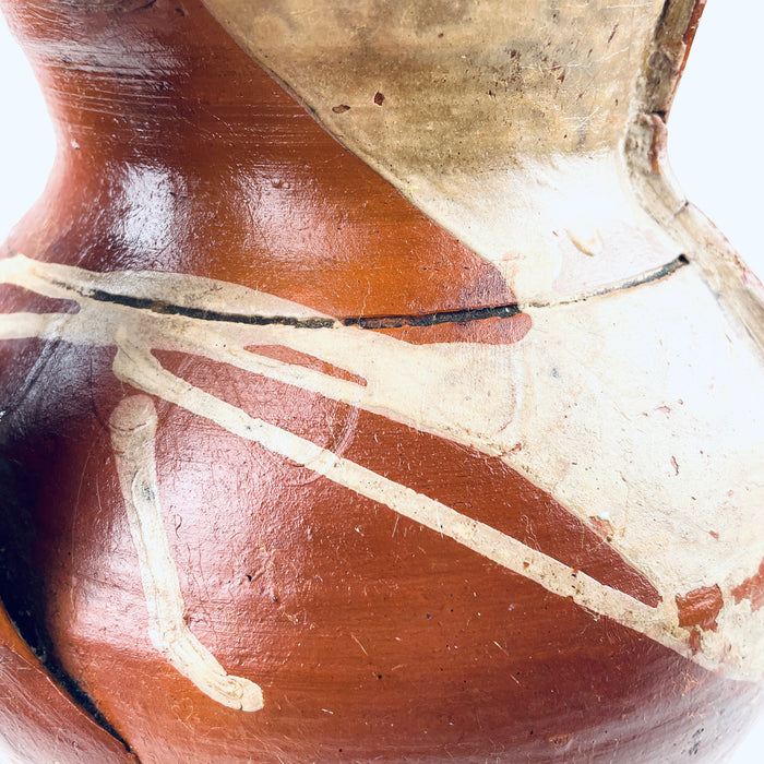 Hand applied loop handle on an antique Spanish orza jar, showing the joined clay construction, worn glaze and natural variations around the attachment point. The red earthenware body and amber brown glazed finish are characteristic of rural utilitarian pottery, making the vessel suitable for Mediterranean decor and rustic home decor.