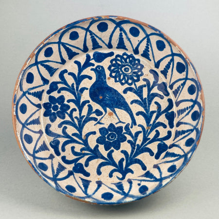 Antique Spanish Fajalauza lebrillo bowl from the late 19th century, hand-painted with a cobalt bird surrounded by Moorish floral scrolls and borders, showcasing Andalusian ceramic artistry in blue over white tin-glaze on terracotta.