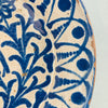 Close-up of the geometric border pattern running around the bowl's edge, featuring repeating cobalt blue leaf-like swirls influenced by Islamic decorative arts, typical of Moorish ceramic traditions in southern Spain.