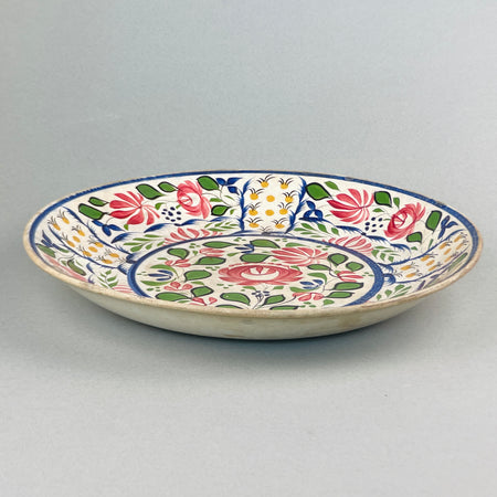 Rear view of late 19th-century English ceramic platter, showing aged glaze and unmarked foot rim with natural wear.