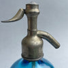 Detail of patinated pewter siphon top stamped "NOVELTY LITRE GARANTI," showcasing vintage French engineering with rustic charm.