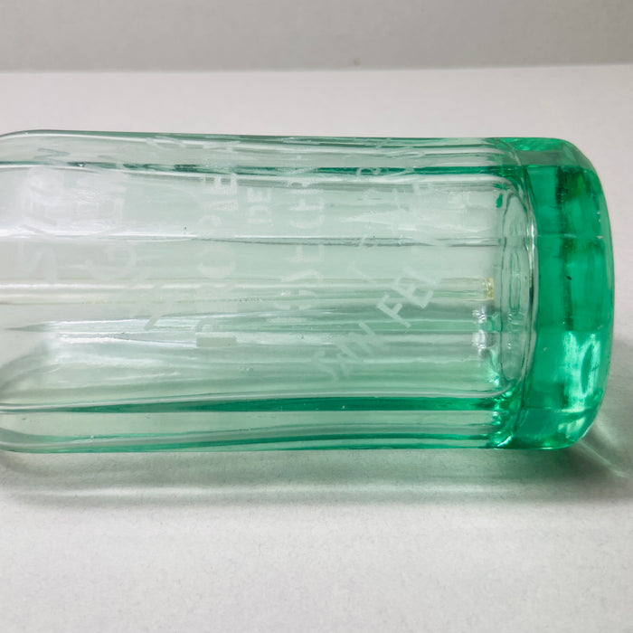 Transparent green vintage soda siphon glowing in studio light, showcasing fluted form, siphon mechanism, and rich Catalan provenance. Unique collector’s piece with visible embossed script and aged coloration on top, appealing to lovers of vintage European glass.