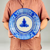 Antique Spanish faience plate attributed to Manises, Valencia, with cobalt blue painting on an opaque warm white tin glaze. The deep charger displays handmade variation in line spacing, pigment density and floral brushwork, together with rim chips, glaze losses, crazing and a historic repaired break that should remain part of its presentation.