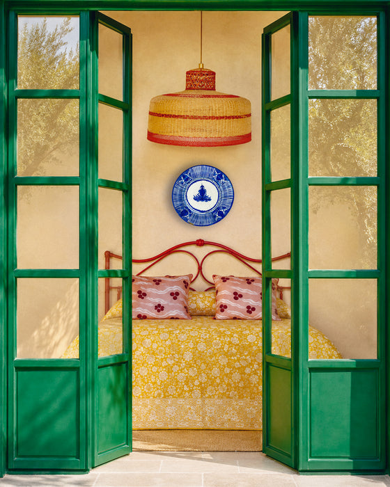 Antique blue charger from Manises, Spain, decorated by hand with cobalt pigment over opaque white tin-glazed earthenware. The circular majolica plate combines a central foliate emblem, dotted inner border, radial line panels and repeated botanical motifs, making it a strong piece of Mediterranean wall decor despite visible antique repairs and rim wear.