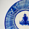 Antique Spanish majolica plate with a five-centimetre depth, slightly raised foot and gently curved earthenware body. The cobalt blue rim and hand-painted Manises decoration continue around the interior, while the reverse carries an F.M.-style mark and historic metal staple repair associated with the plate’s long working life.