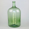 Full view of antique French green glass demijohn with elegant tall neck and handblown silhouette, standing upright against a neutral background.