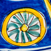 Hand painted Spanish folk art ceramic from Manises, centered by an expressive bird drawn with spontaneous brown lines and washes of yellow, blue and green. The surrounding flower panels and geometric rosettes create a dense radial composition across the tin glazed earthenware plate, ideal for collected wall decor.