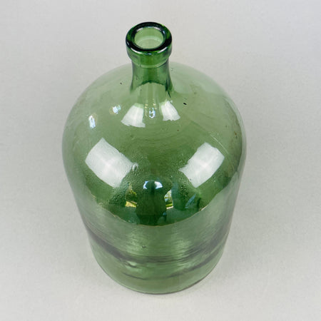 Close-up of the demijohn’s neck and rim showing classic handmade detail and deep olive green hue typical of 1940s glassware