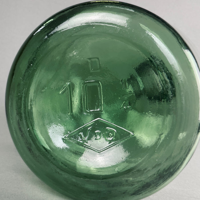 Close-up shot of bottle base with embossed diamond stamp and vintage number, indicating mid-century production.