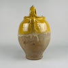 A close-up of the yellow glazed terracotta gargolette reveals subtle crackling, natural wear, and color variations that confirm its 19th century origin. This handcrafted cruche form is perfect for Mediterranean decor, cottage decor, and French country decor, bringing warmth and authenticity to any space through its rustic handmade character.