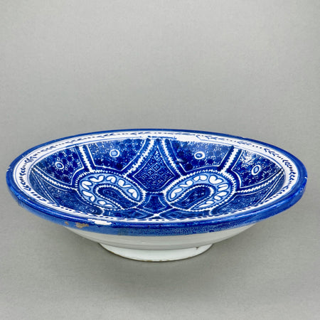 Side view of Moroccan terracotta bowl with wall-mount, emphasizing its wide curved form and decorative function.