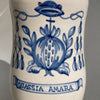 Talavera de la Reina ceramic apothecary jar, traditional Spanish majolica featuring vibrant cobalt blue detailing and a stylized botanical symbol referencing historic medicinal uses.