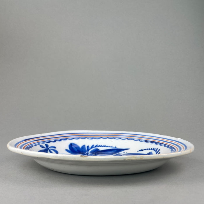 Vintage Spanish charger, close-up of the border area with scalloped detailing and orange concentric lines, traditional to mid-century Spanish pottery.