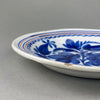 Cobalt blue majolica platter, with floral brushwork and orange rim banding, zoomed in to emphasize artisan hand-painting details.