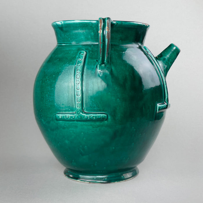 French green-glazed water jug with twin handles and conical spout, positioned upright to emphasize its rounded proportions, decorative relief work, and excellent vintage condition.