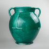 Full profile view of antique French gargoulette featuring upward spout, looped side handles, and rare green-glazed surface, set against a neutral background to showcase the classic rustic silhouette.