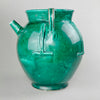 Rare vintage French green-glazed gargoulette with twin handles and relief bands, styled on rustic surface. Horizontal image of large French gargoulette showing off the rare proportions, rich green glaze, and softly aged patina, ideal for use as a centerpiece, statement vessel, or decorative art object.