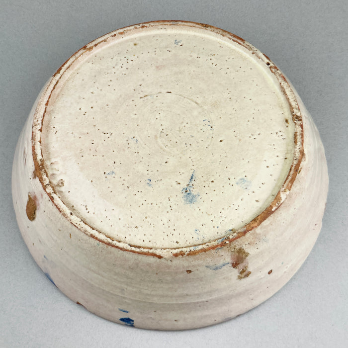 Underside view of antique bowl showing unglazed terracotta base and natural firing marks, typical of handmade 19th-century Spanish ceramics.