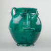 Rare vintage French gargoulette water jug with deep green glaze, twin handles, and a sculptural terracotta body, styled on a rustic surface with natural lighting to highlight its relief bands and handcrafted character.