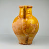 Yellow and brown ceramic vase on a white background. Top-down view of gargolette showing inner glaze and circular opening with rustic wear, suitable for use as a vase for dried branches or simply displayed as a statement antique pottery piece in rustic interiors.