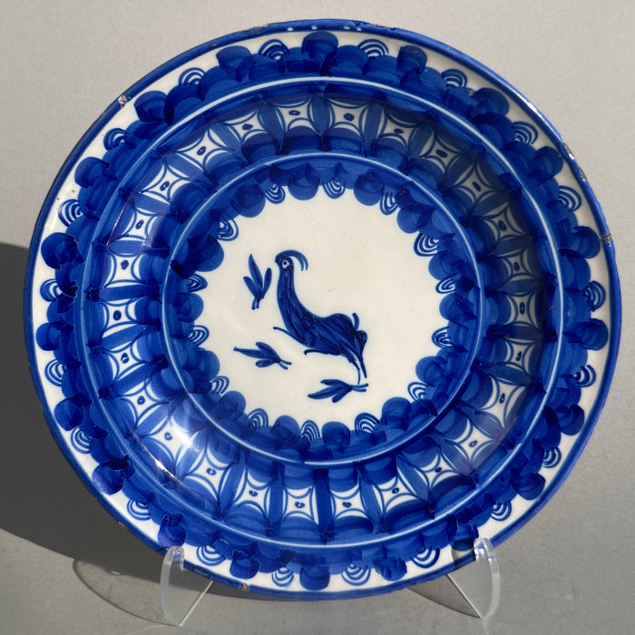 Antique Spanish Manises plate, hand-painted ceramic with blue and white bird motif, photographed from the front to show full decorative design and symmetry typical of 19th-century Valencian pottery.